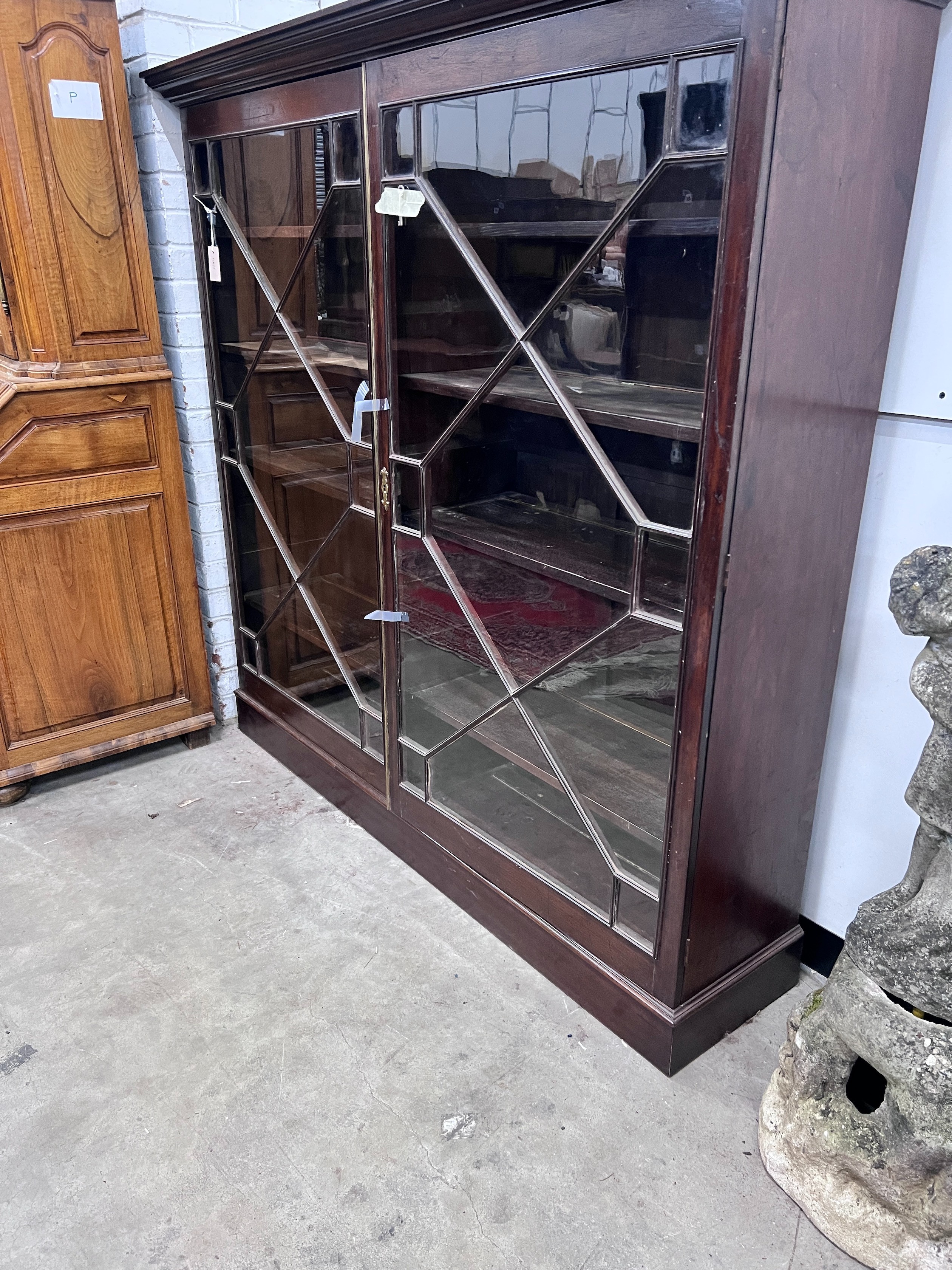 A George III mahogany two door bookcase, adapted, width 164cm, depth 40cm, height 159cm, *Please note the sale commences at 9am.
